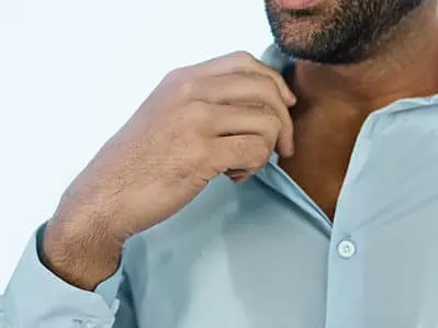 man excessively sweating through his shirt from hyperhydrosis