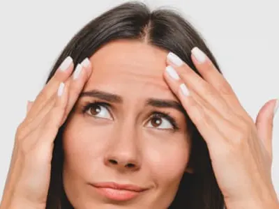 sad woman looking for wrinkles on her face isolated in white background.