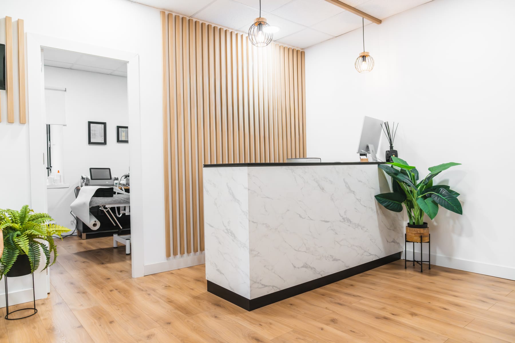 A bright reception area with a marble desk and a wood-slat wall