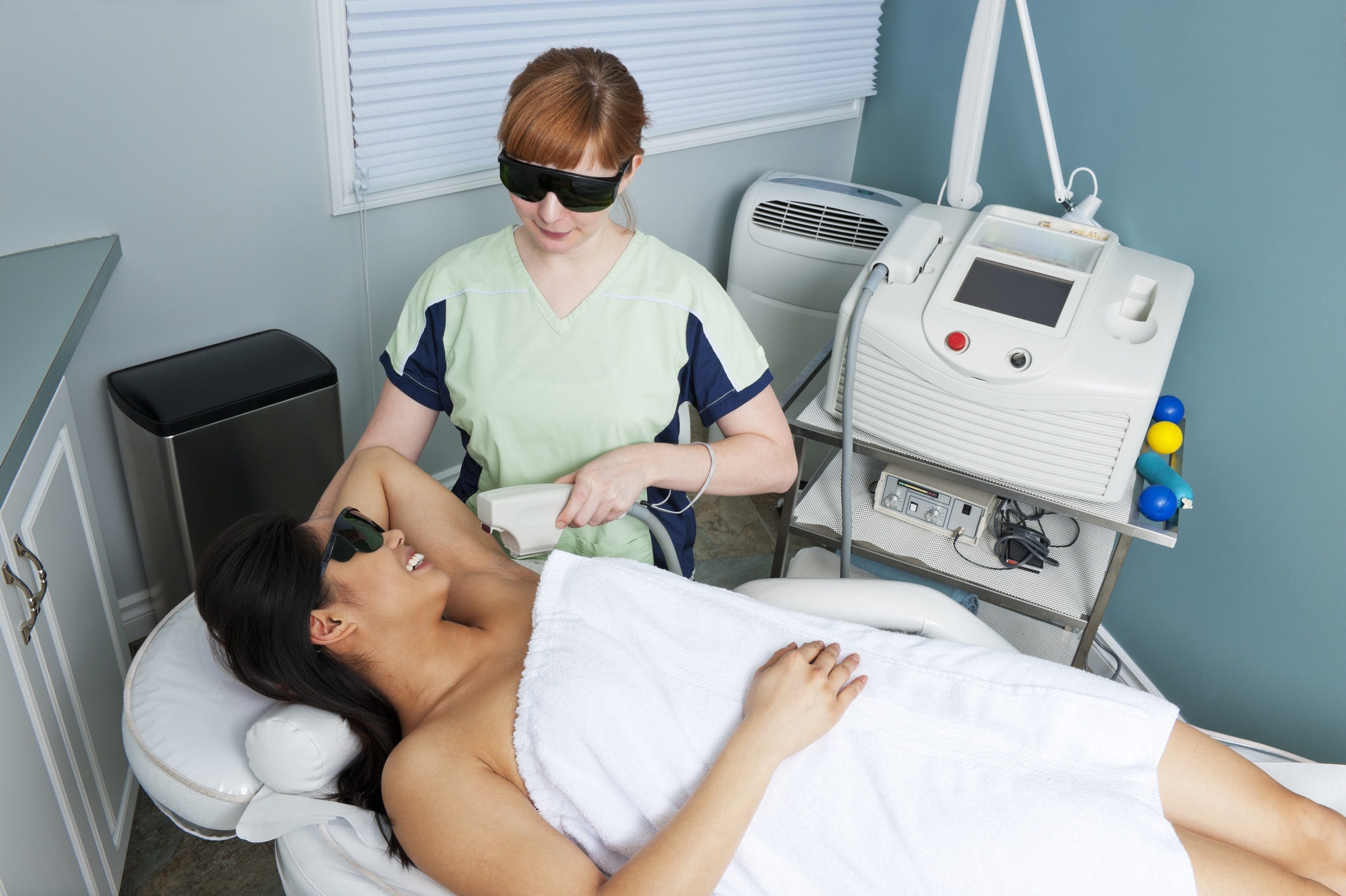 A woman undergoing laser hair removal on her armpits.Click Here for More of this series: