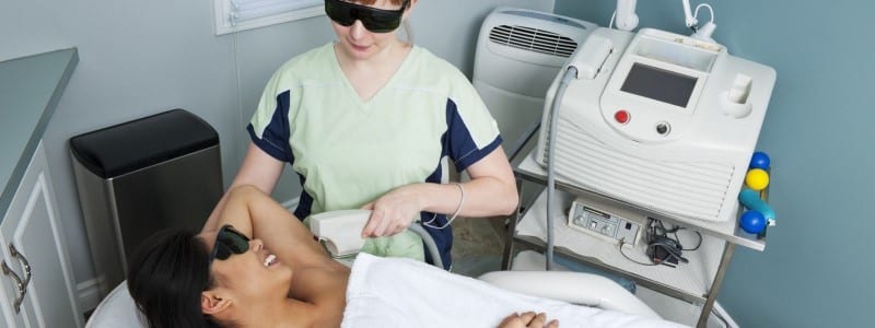 dermatologist performing laser hair removal on a patient's underarm area