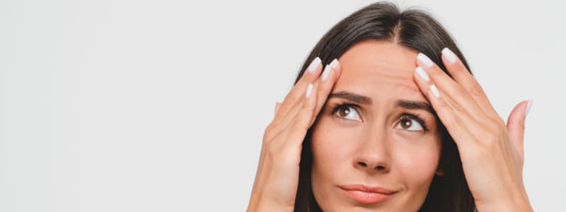 sad woman looking for wrinkles on her face isolated in white background.